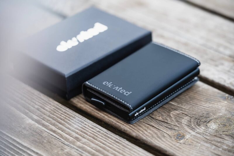 elevated-plus-2.1-kaarditasku-black-flat-lay-karbi-kõrval KT006 - Elevated-plus-2.1-kaarditasku-black-flat-lay-karbi-kõrval