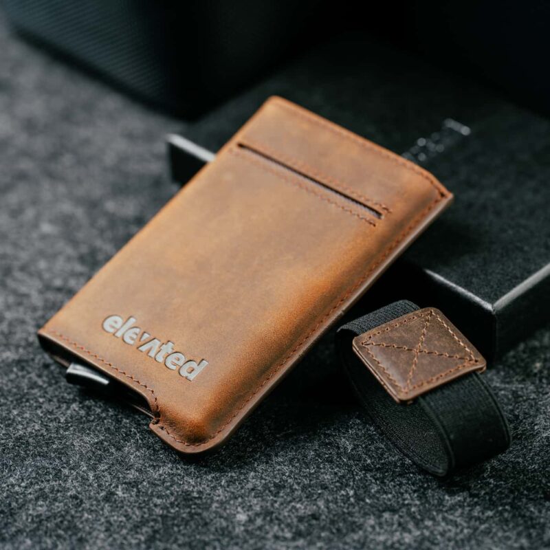kaarditasku-elevated-extra-slim-pruun-eemaldatava-paelaga Elevated Extra Slim 1.0 pähklipruun kaarditasku koos eemaldatud elastse paelaga, näidates toote minimalistlikku disaini.